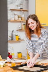 Homemade cookies recipe. Cheerful lady arranging dough on sheet pan, baking gingerbread biscuits.