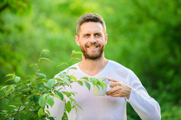 Naklejka na ściany i meble ecological life for man. man in green forest. morning coffee. healthy lifestyle. nature and health. happy man with cup of tea. breakfast refreshment time. drink tea outdoor. Morning inspiration