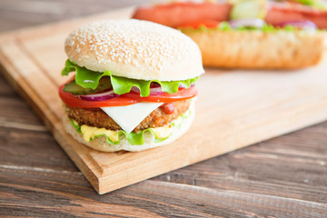 Delicious fast food. Hot dogs and hamburgers on the wooden background.