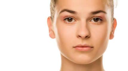 Fototapeta premium Portrait of young serious woman with light makeup on white background