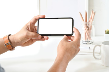 Businessman's hand using blank white screen mobile smart phone.