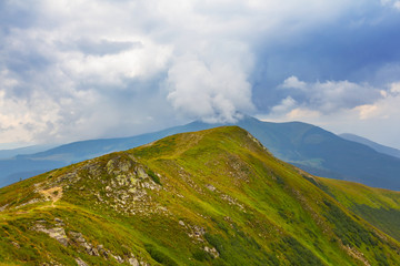 green mountain ridge under a dense clouds