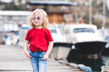 Happy baby girl 3-4 year old posing over sea at background. Summer time.