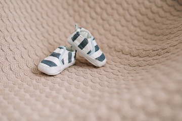 Newborn boots. Baby booties on knitted fabric. Baby boy shower concept. copy space, top view 