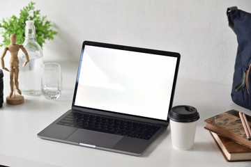Designer workspace with blank white screen laptop and office accessories