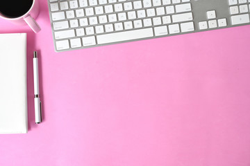 Pink desktop with computer and copy space