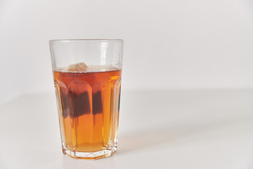 A glass of tea on the table. Close-up. Glass on a plain background