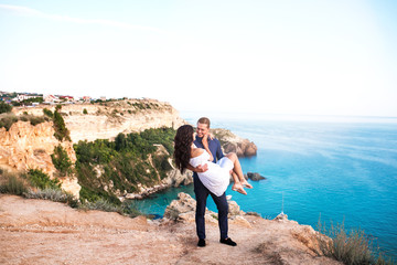 Romantic couple on the rock near beautiful sea beach.