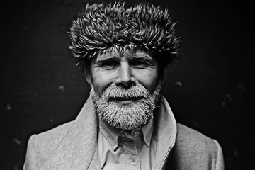 brutal man with a beard in winter clothes / portrait person with a gray beard, hipster warm clothes winter
