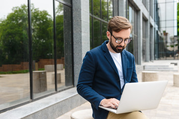 Attractive confident young bearded man wearing jacket