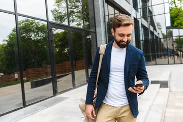 Obraz premium Attractive young bearded man wearing jacket walking