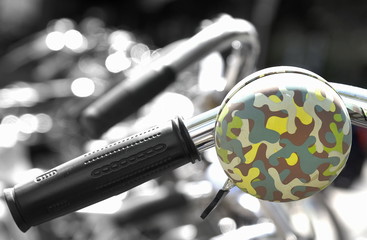 Olivgrün gefleckte Klingel an einem Fahrradlenker