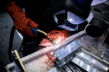 Welding steel with spread spark and lighting around.