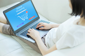 Close up woman sitting and shopping online on laptop computer in add to cart function webpage