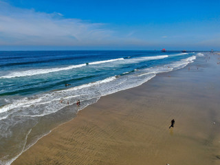 Aerial view people enjoying the beach during sunny day. Huntington Beach, Southeast Los Angeles,...