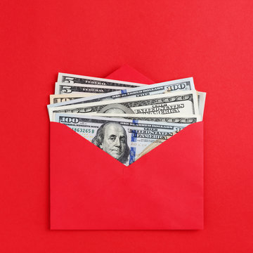American dollars in cash in red envelope on minimal style bright background. Money mail, finance wealth concept. Flat lay.