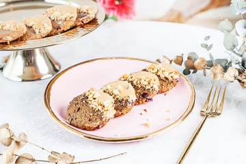 Veggie healthy cookie with carrot served on rose plate above white background. Close up horizontal food photo. Gluten free, healthy dessert. Vegan food and sweets. Snack. Copy space