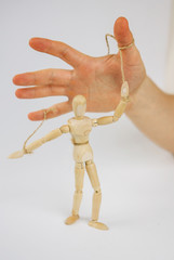 Manipulation of wooden puppet.Puppeteer. The hand controls the puppet strings. Manipulation of the ...