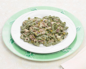 Piatto di pasta verde con piselli e speck, pasta italiana