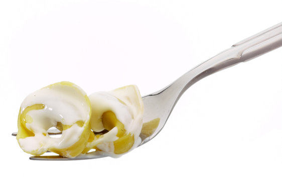 Forchetta con cappelletti alla panna, primo piano, pasta italiana