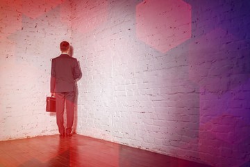 Full length rear view of businessman standing in corner at office