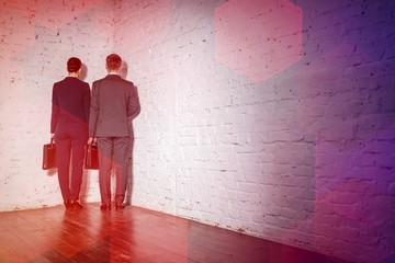 Full length rear view of business colleagues standing in corner at office