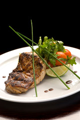 Well-done steak with suace and vagetables. Reastaurant dishes on the wooden table. Food photo for restaurant menu. Selective focus.