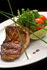 Well-done steak with suace and vagetables. Reastaurant dishes on the wooden table. Food photo for restaurant menu. Selective focus.