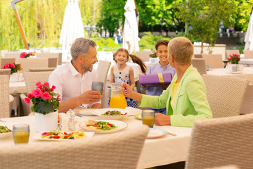Grandparents feeling surprised seeing grandchildren with presents