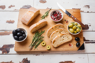 Italian ciabatta bread with olives and rosemary on a wooden Board.