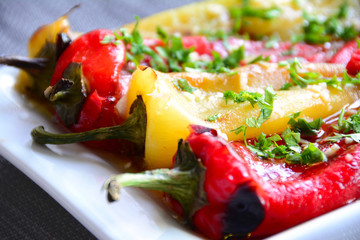 Roasted red and green peppers marinated with herbs and garlic served on plate
