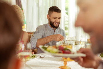Handsome dark-haired man having lunch with parents