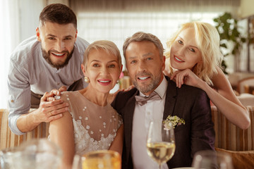 Young man and woman hugging parents getting married