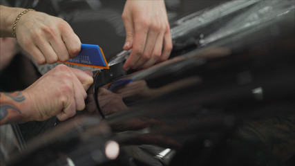 closeup peeling off protective film from a car. closeup peeling film from a car