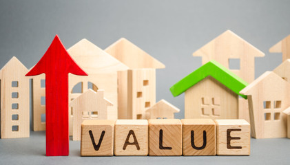 Wooden blocks with the word Value, up arrow and wooden houses. The concept of raising property...