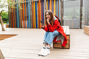 Cheerful attractive young girl wearing raincoat