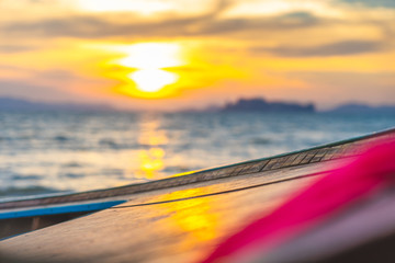 Traditional Long tail Thai Boat resting on the beach as the sun sets on a beautiful Krabi beach, perfect sunset at a dream destination, holiday, vacation.