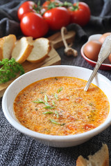 Italian food. Stracciatella tomato soup: parsley, eggs and parmesan cheese