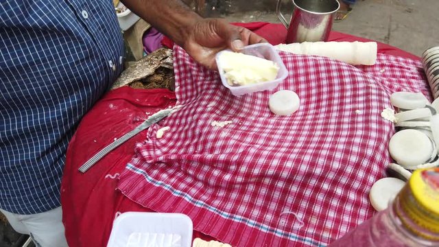 Street food- Kulfi Falooda, a rich, popular Indian delicious summer dessert with homemade pista ice-cream topped with vermicelli, sabja seeds, rose syrup. 4k 60fps close-up stabilized handheld