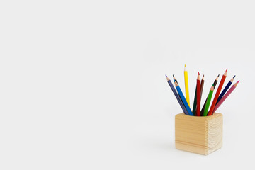 Fototapeta premium colorful pencils for drawing in a wooden cube