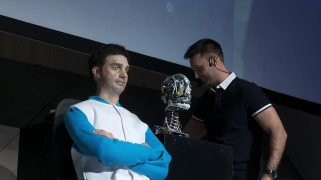 Humanoid robot man on stage. Innovative development in robotics and artificial intelligence. Android Presentation. Modern Robotic Technologies. The robot shows emotions.