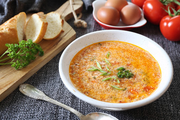 Italian food. Stracciatella tomato soup: parsley, eggs and parmesan cheese