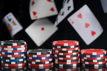 on a black background and flying cards, pyramids of chips, for playing poker