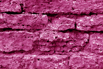 Old grungy brick wall texture in pink tone.