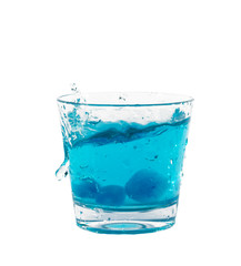 Blue ice cubes splashing into glass of water.