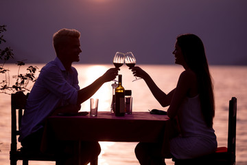 Happy couple on summer evening having romantic dinner outdoor
