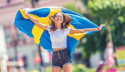 Foto op Aluminium Happy girl tourist walking in the street with sweden flag © weyo