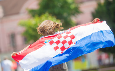 Happy girl tourist walking in the street with croatian flag
