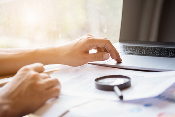 man looking through a magnifying glass to documents. Business assessment and audit. Magnifying glass on a financial report. Close-up Of Checking Bills With Magnifying Glass.Concept of search.