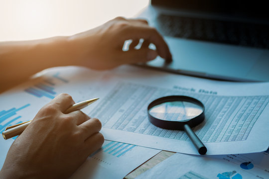 man looking through a magnifying glass to documents. Business assessment and audit. Magnifying glass on a financial report. Close-up Of Checking Bills With Magnifying Glass.Concept of search.